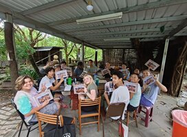group smiling holding up art