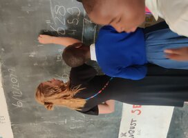 Volunteer teaching a class of eager students in a Tanzanian school