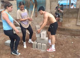 Construction volunteers arrainging bricks