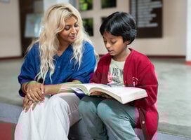 Volunteer reading with child.