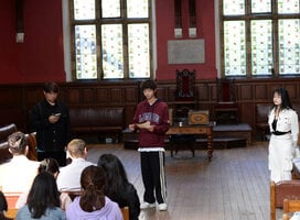 Three students presenting in the Oxford Union