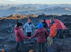 Crew circles up on a rocky summit