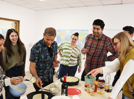 Students participating in a crêpe-making workshop as part of a French language immersion program in Paris.