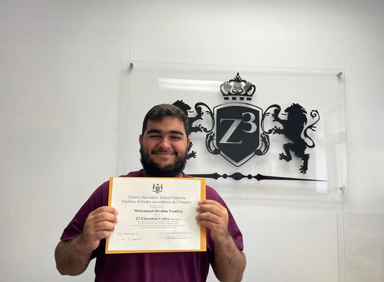 A graduating high school student holding a OSSD diploma from Z3 Education Centre