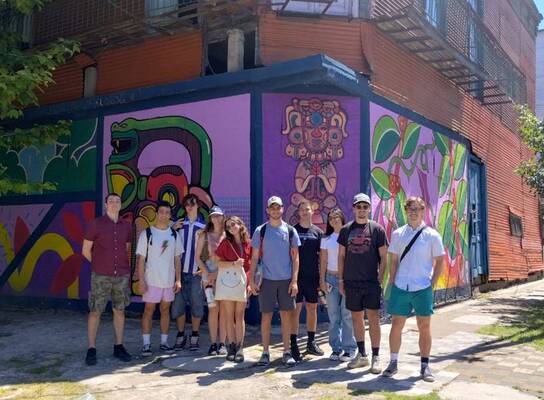 Gap internship group posing in front of street art in Buenos Aires