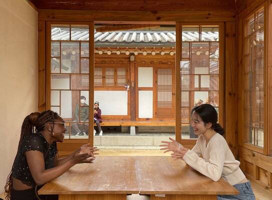Gap year students in Seoul chatting at table