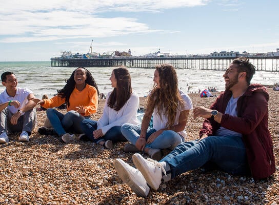 Summer School students laughing on Brighton beach