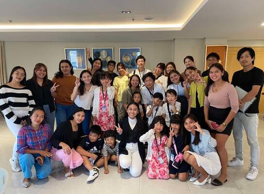 Graduating students posing with their teachers during the ceremony.
