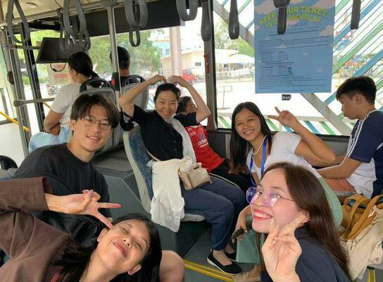 Students and a teacher riding a bus for their Friday practical lesson.