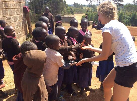 Volunteer celebrating with school children 