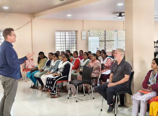 A room of students attending a course, watching the trainer. 