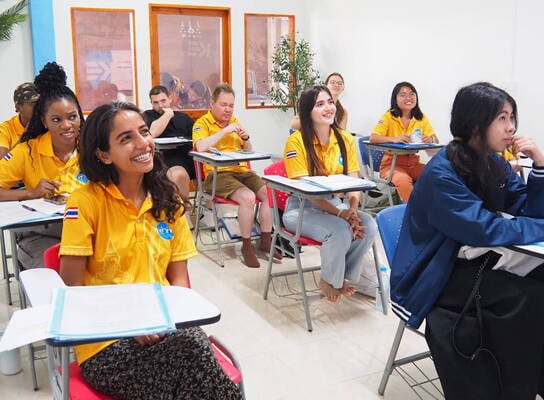A group of international students sitting in a vibrant classroom during an orientation session in Sukhothai, Thailand.