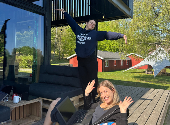 Two interns working outside on bean bags on a porch