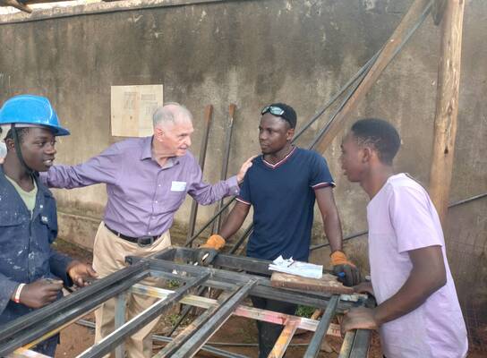 Volunteer supporting vocational training workshop at RMFSL Skilling Station in Kampala