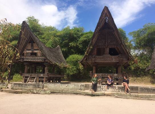 AFS Students sitting in front of old traditional houses in Indonesia