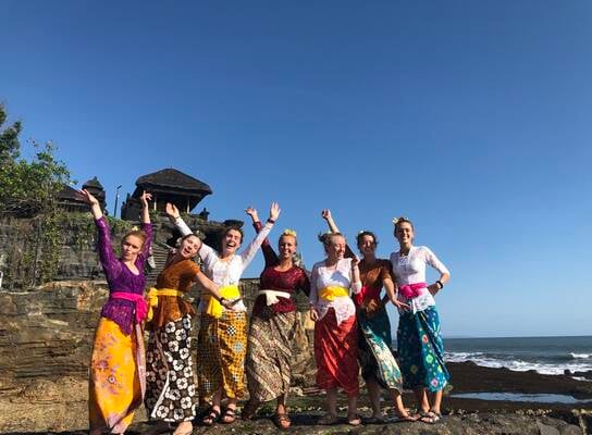 Students in traditional clothes on beach in Indonesia