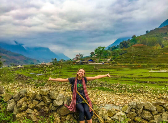 Student standing in front of rice fields