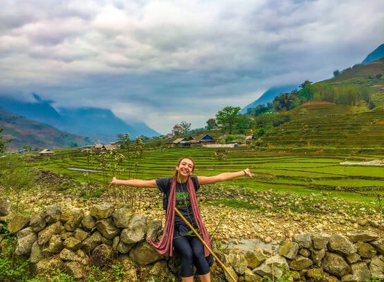Student standing in front of rice fields