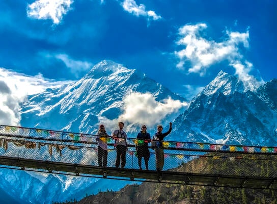 Students pose on bridge in Himalayas.