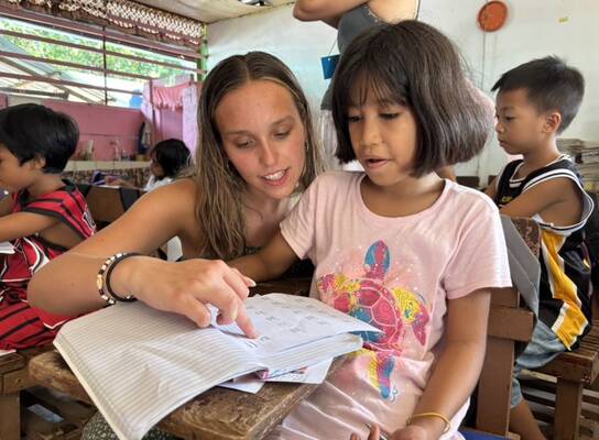 Volunteer teacher helping student 