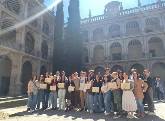 Students with certificates at historic university campus 
