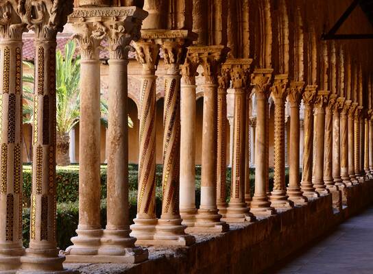 Row of decorated medieval columns in the Monreale Cathedral cloister, Sicily