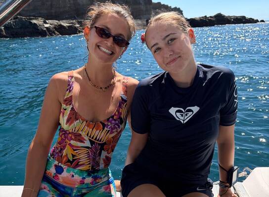 two girls sitting on a boat