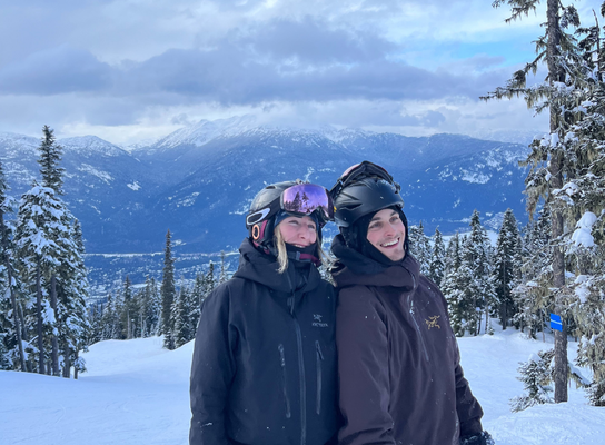 Two people smiling on a snowy mountain