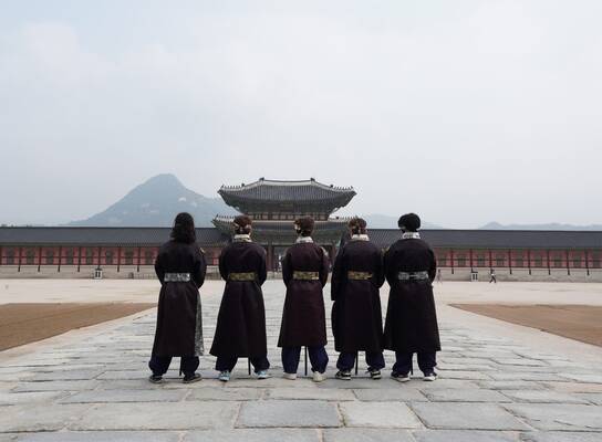 Teen travelers dressed in Korean Hanbok at Gyeongbokgung palace in Seoul.