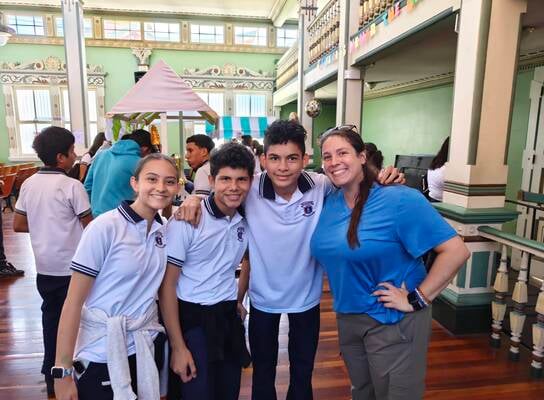 Volunteer helping Costa Rican students practice English through classroom activities and conversation in Heredia.
