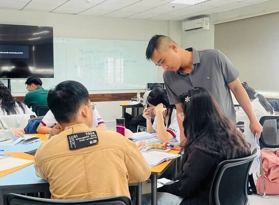 TESOL trainee supporting Vietnamese students during a classroom activity