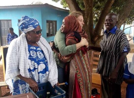 Volunteer hugging local child