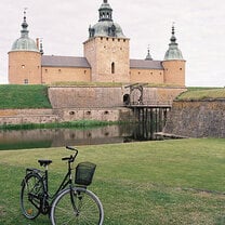 bike parked on grass outside old building