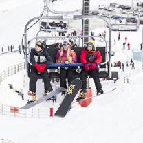 snowboards on a ski lift in New Zealand mountains