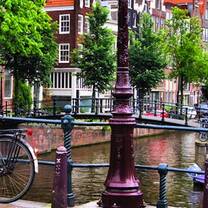 Bike resting on railing of a canal bridge in Netherlands