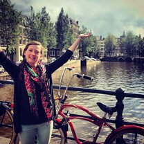 Woman standing with a bike on a canal bridge in Netherlands