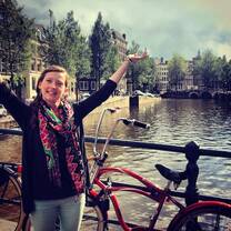Woman standing with a bike on a canal bridge in Netherlands