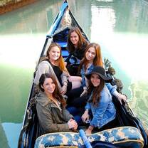 A group smiling on a gondola ride in Venice
