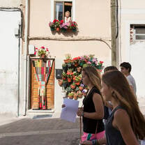 Four students walking down the street in a small Spanish town, as an older señora watches them from her window