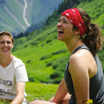 girl laughing with red bandana on green hill