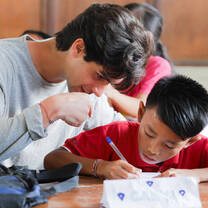 Volunteer Patricio helping his student through a written exercise during his volunteer program in Bali.
