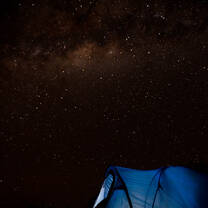 A tent in Tanzania in front of a starry landscape