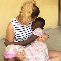 Volunteer giving warm cuddle to a child