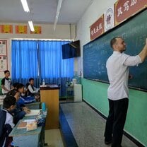 teacher writing on chalkboard