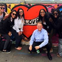 students pose in front of graffiti