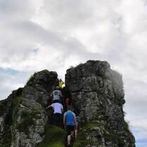 Students climbing large rock formation