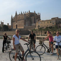 students on bikes in front of Spanish castle
