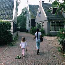 little girl and woman walking on cobblestone street