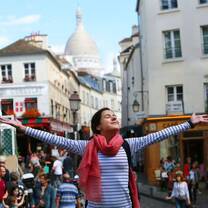 Student with arms outspread in French village