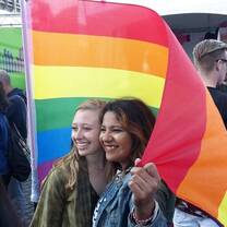 two women posing with pride flag